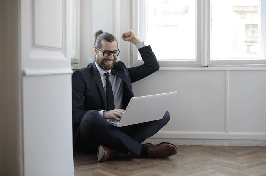 man glad framför bärbara datorn